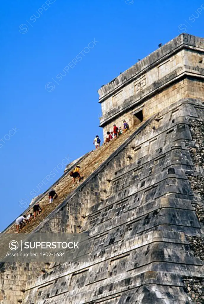 Mexico Yucatan State Chichen Itza El Castillo tourists climbing the pyramid