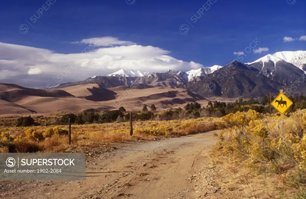 USA Colorado Great Sand Dunes National Park dirt road  and sand dunes with Sangre de Cristo Mountains with horseback riding sign
