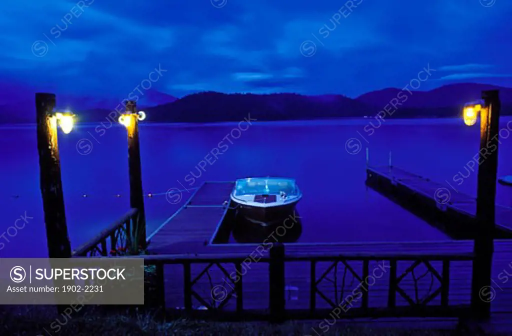 USA New York Lake Placida boat moored at a dock at twilight