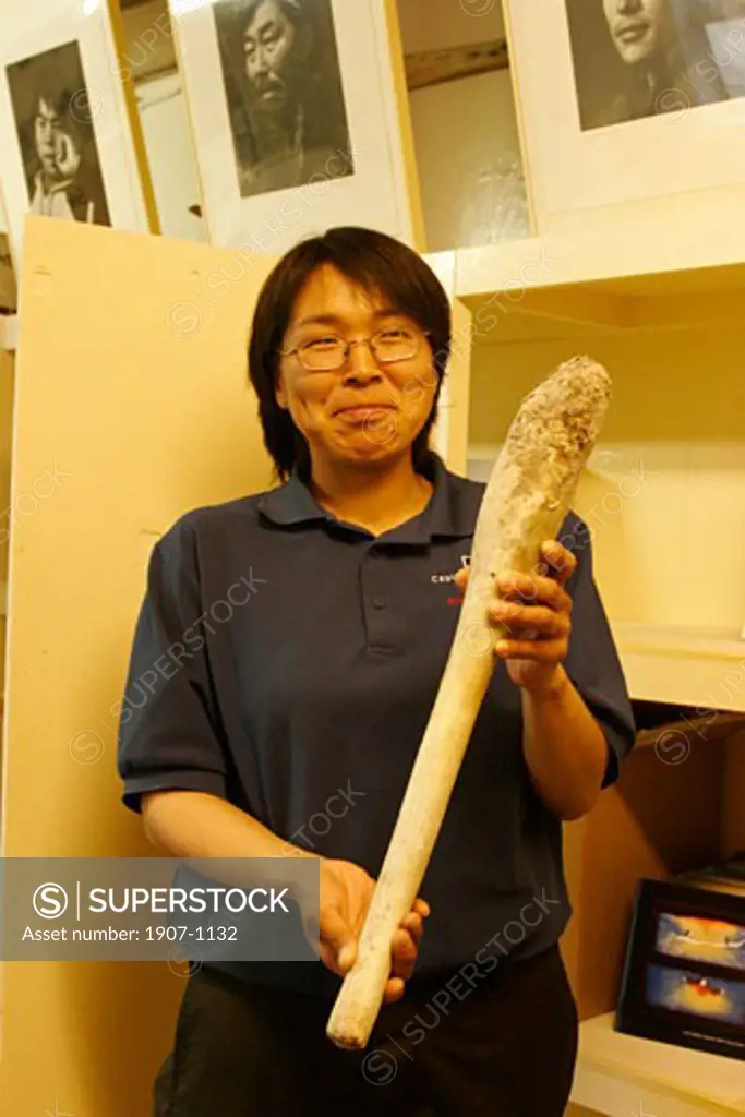 A young inuit woman presenting a walrus penis  in the Cape Dorset Museum  on Baffin island