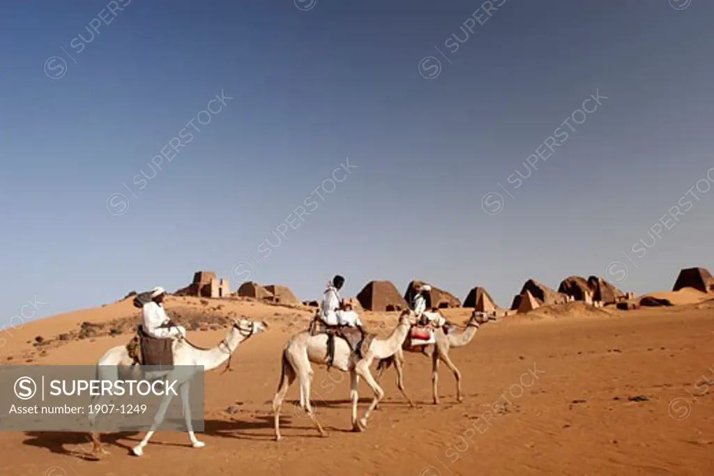 Three camel riders in front of the ancient Meroe pyramids