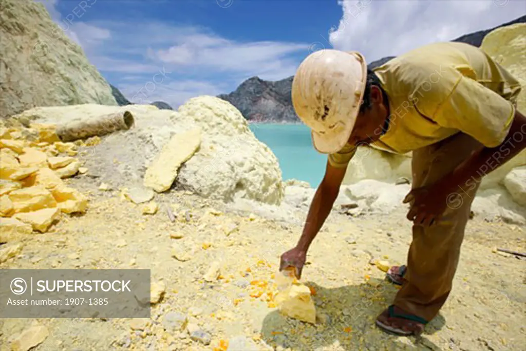 Sightseeing on the lake of the crater of the Kawa Ijan vulcano where a sulphur mine constantly smokes a sulphur worker is modeling some souvenirs in order to earn a few money with visitors Baluran national park Java Indonesia