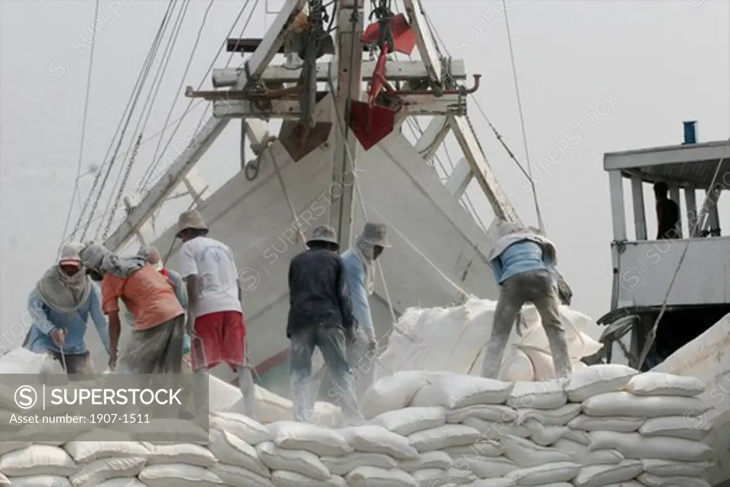 Coolies working to carry off quicklime from the pilisis Sunda Kelapa harbour of Jakarta Java Indonesia