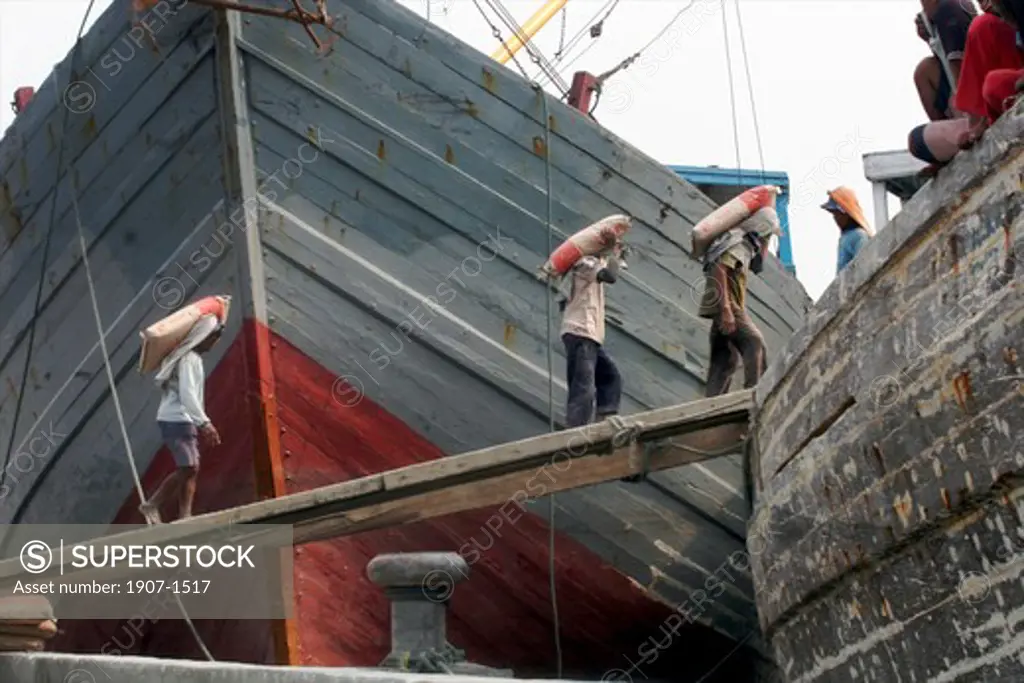 Coolies working to carry cement on the pilisis Sunda Kelapa harbour of Jakarta Java Indonesia