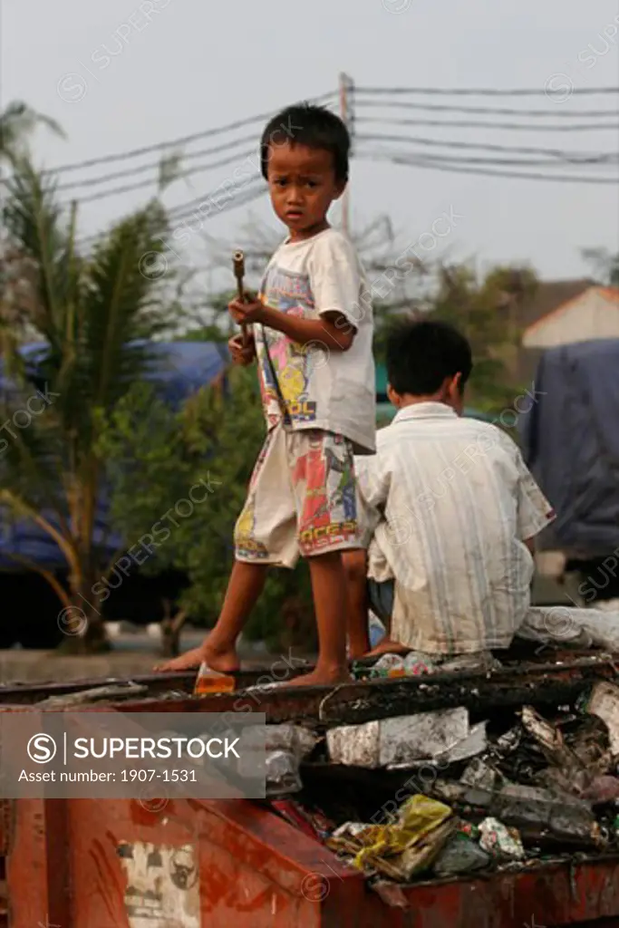 A child looking for food in a garbage can in Sunda Kelapa harbour of Jakarta Java Indonesia