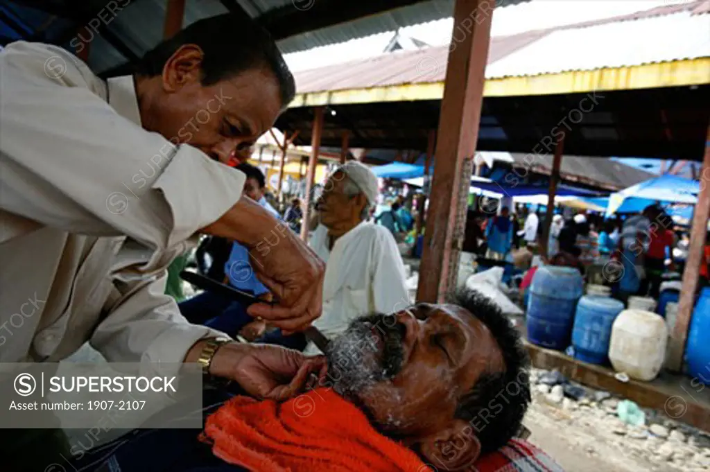 Hairdresser at the market of Parapat close to lake Toba Sumatra Indonesia