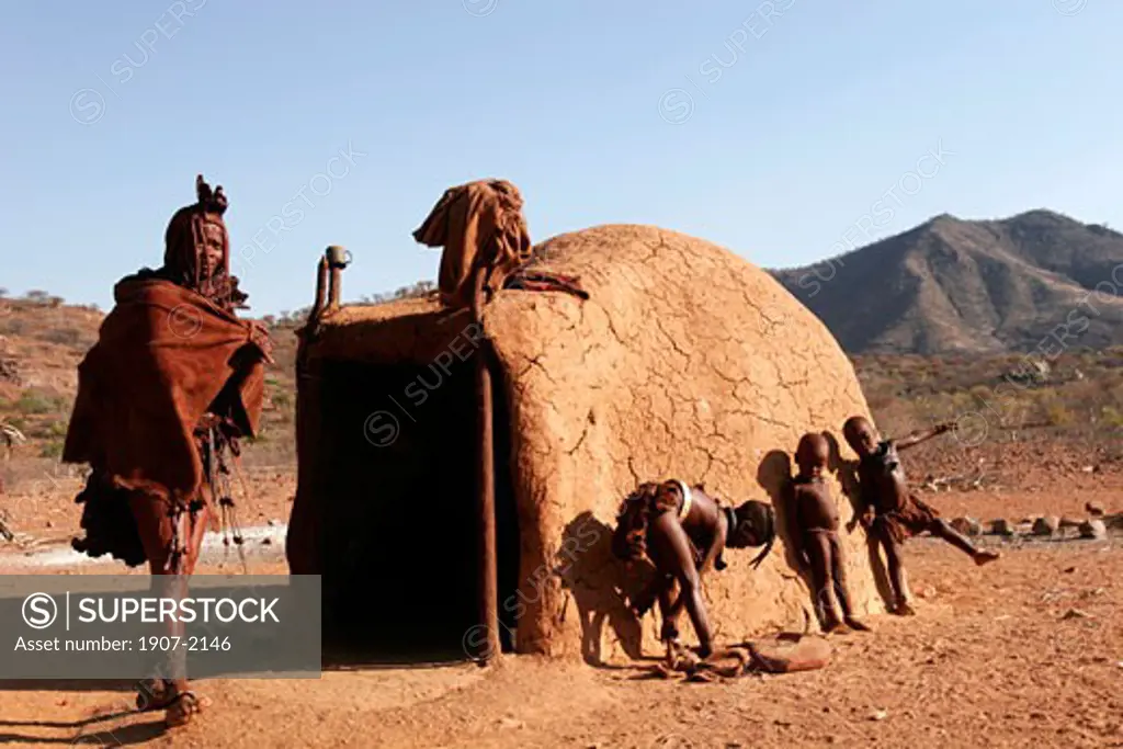 A Himba family near her house in a Himba village of the Kunene river  at the boarder with Angola