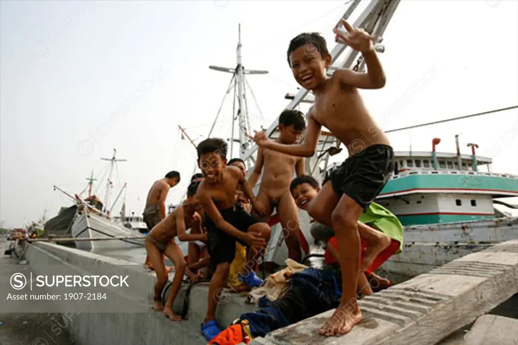 Children having a bath in Sunda Kelapa the harbour of Jakarta Java Indonesia