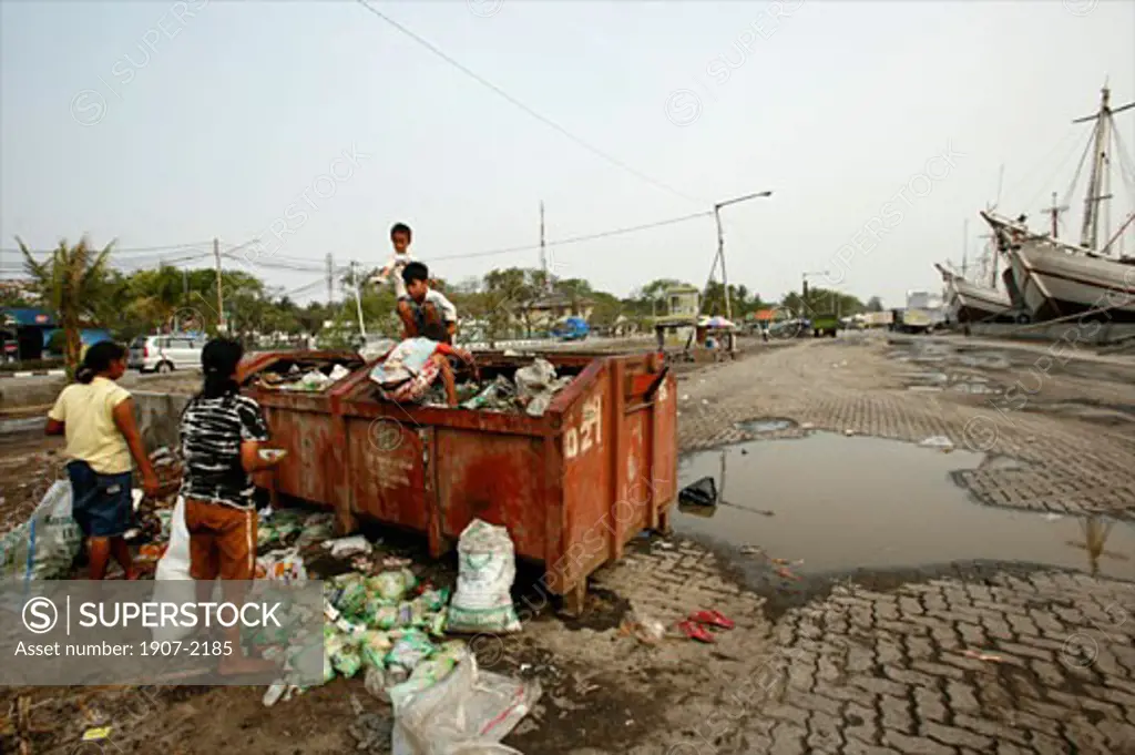 Children and women looking for goods and food in a garbage can of Sunda Kelapa Jakartas harbour Java Indonesia