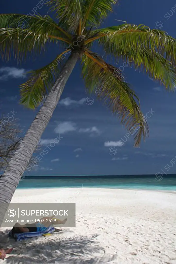 Sunbath on a beach of Embudu island Maldives