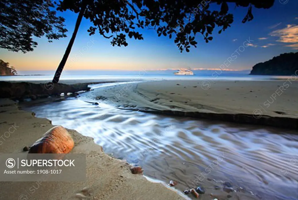Lanscape shot of a beautiful beach in the morning located Puntarenas  Costa Rica compliment by a large cruise boat and a coconut Rincon de la Vieja