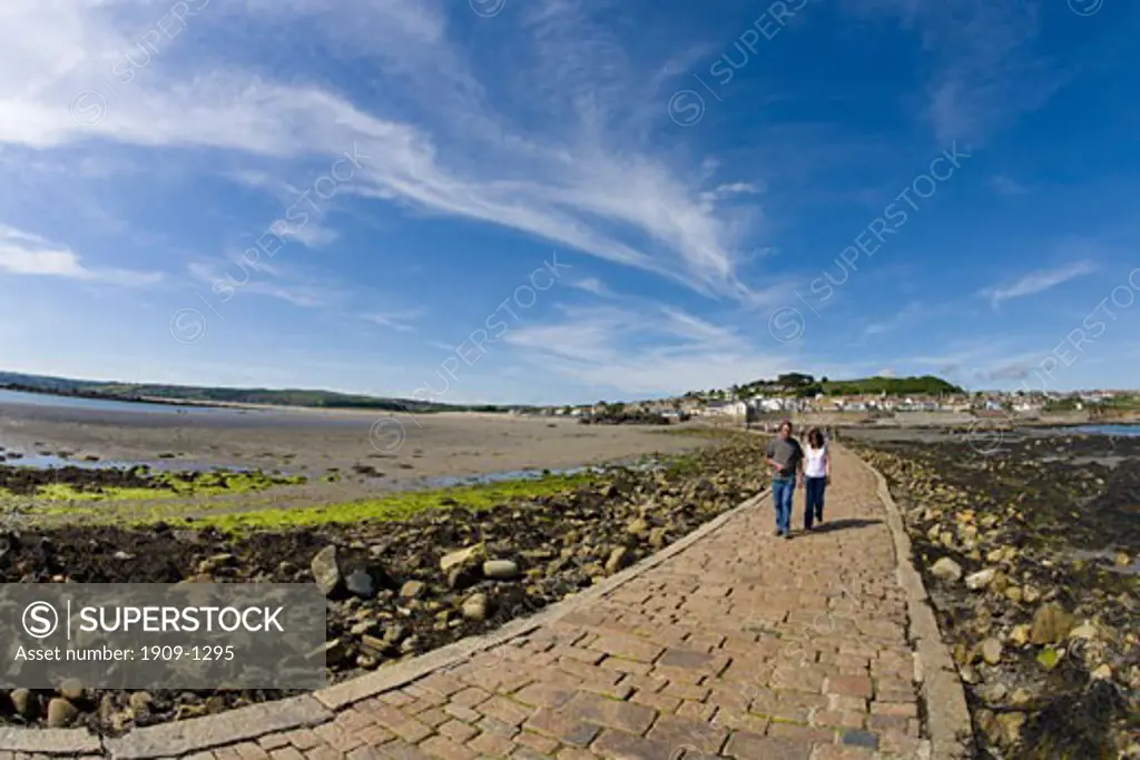 Couple stroll along Marazion Bay and St Michaels Mount causeway in late summer sunshine Cornwall West Country England UK United Kingdom GB Great Britain British Isles Europe EU