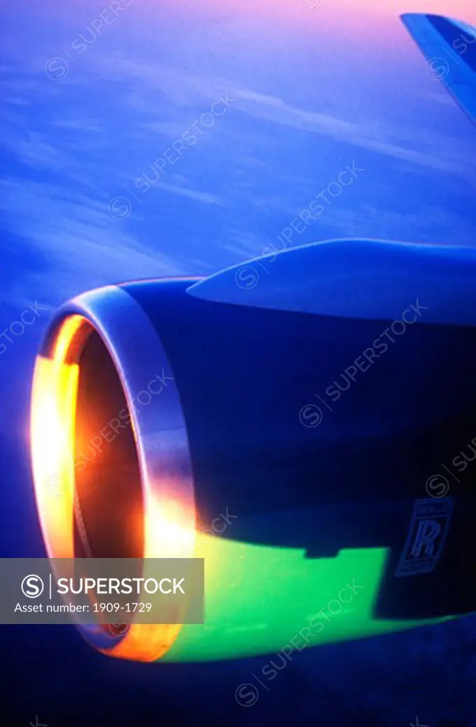 Jet Aircraft window view of sun setting on clouds over Europe from 30 000 feet with close up close up closeup of Rolls Royce Engine