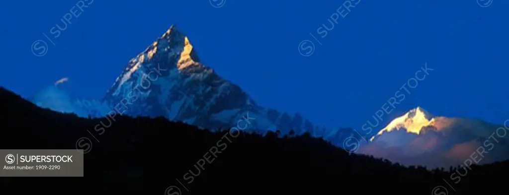 Panoramic photo of the Nepali Himalayas including Fishtail Mountain Machhapuchhare an unclimbed sacred peak and Annapurna III in late evening sun from Phewa Lake Pokhara Annapurna region Nepal Asia