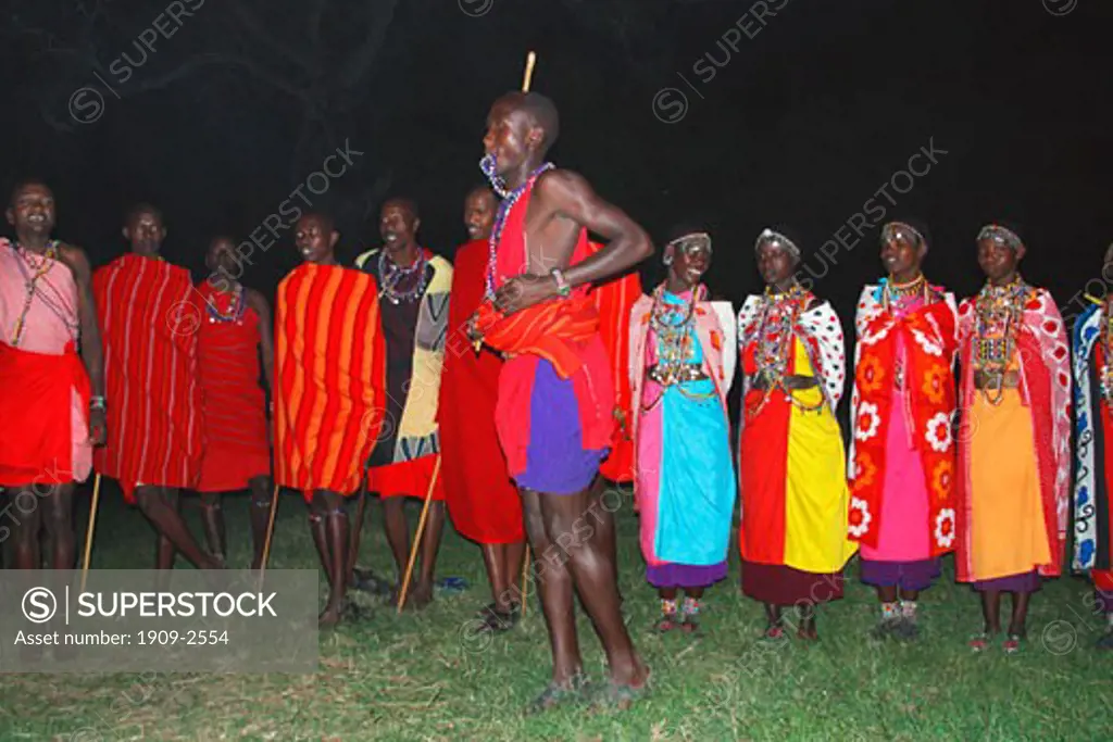 Masai warriors and african women dancing at night for tourists in Masai Mara National Nature Reserve Kenya East Africa