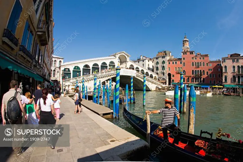 Rialto Bridge hotel and gondolier in gondola Grand Canal with tourists in summer sun sunshine Venice Veneto Italy Europe EU