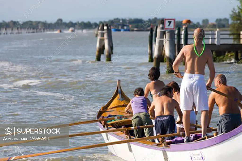 Italian family rowing a boat across the venetian lagoon Venice Veneto Italy Europe EU