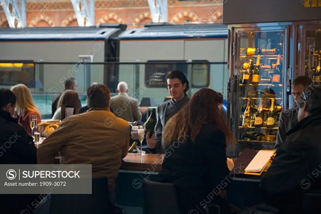 Travellers passengers relax at the longest champagne bar in Europe at St Pancras international eurostar railway station London England UK United Kingdom GB Great Britain British Isles Europe