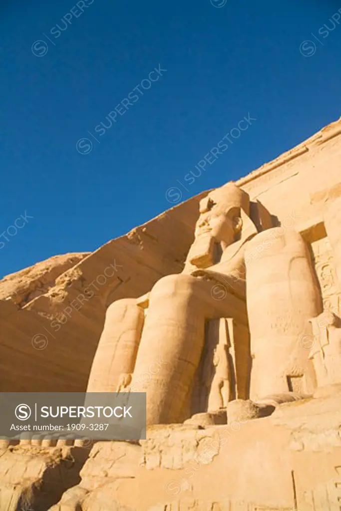 Abu Simbel Temple entrance with statue of Ramses II in early morning sun sunshine Egypt North Africa