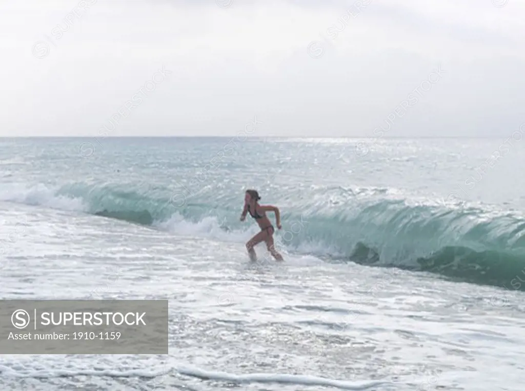 Girl 12 years splashes in warm and gentle Mediterranean surf  Italy  Liguria