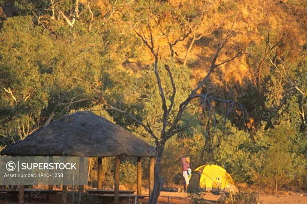 Woman in front of tent camping at MacDonnell Campground near  Alice Springs Red Center AUSTRALIA Northern Territory