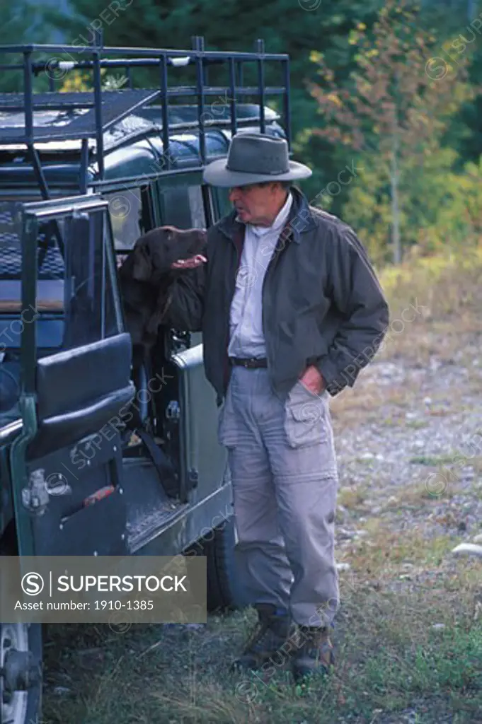 Man patting dog in old Land Rover vehicle Canmore CANADA Alberta