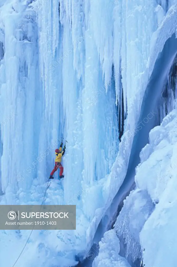 Man climbing steep waterfall ice looking upwards Canmore CANADA Alberta
