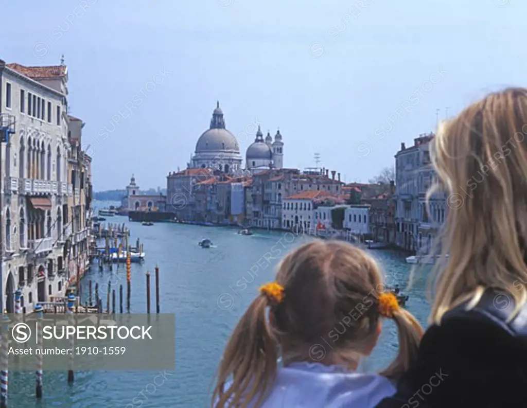 Mother and daughter looking down Grand Canal towards St Marks cathedral constructed by unknown architect circa 1050 ITALY Veneto