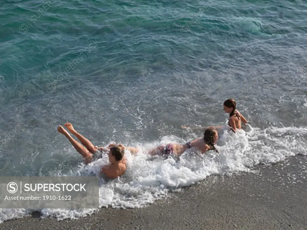 Kids playing in gentle surf in Mediterranean SeaI ITALY Liguria