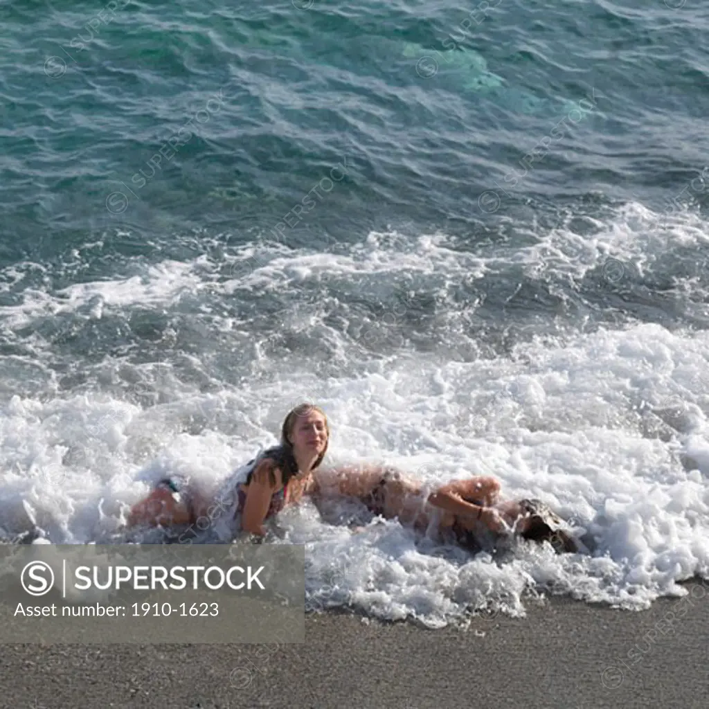 Kids playing in gentle surf in Mediterranean Sea ITALY Liguria