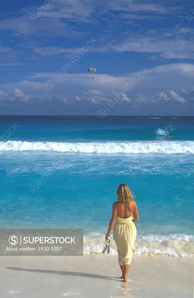 Woman entering beautiful caribbean waters from white sand beach Cancun MEXICO Quintana Roo Cancun