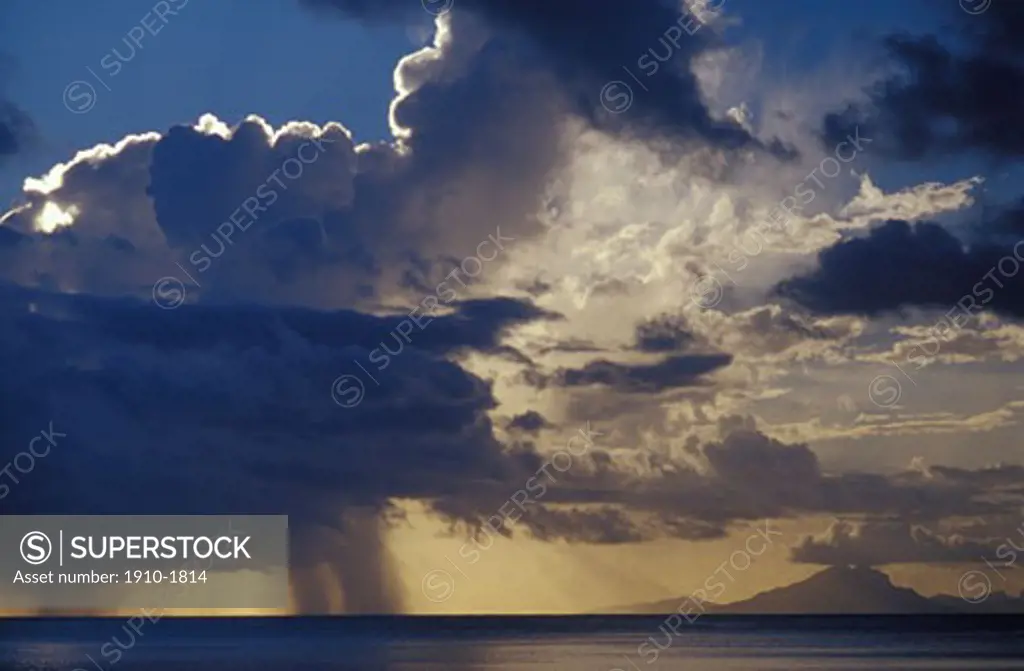 Distant thunderstorm and island in the French Polynesian chain at sunset TAHITI French Polynesia Huahine