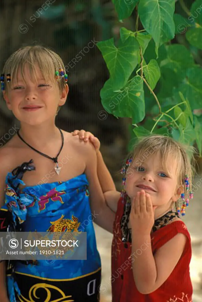 Kids 3  6 yrs wearing sarongs and sundresses on beach in jungle THAILAND Krabi Province