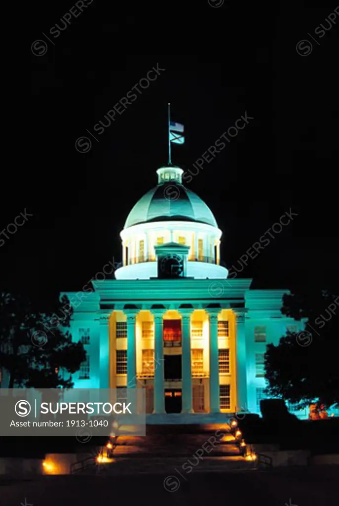 Alabama Capitol at night with the flags at half mast