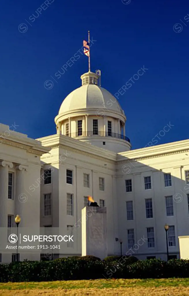 Alabama Capitol with flags at half mast and veterans monument