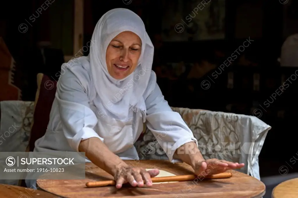 A Turkish woman rolling dough at a restaurant in Istanbul, Turkey.