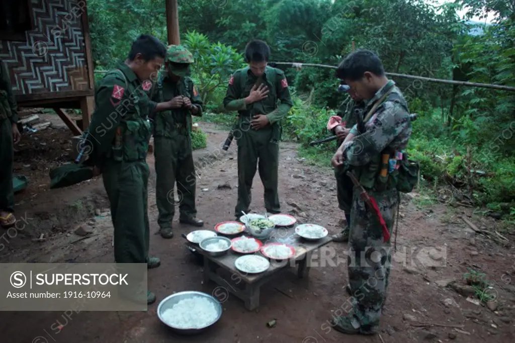 KIA's members pray before the breakfast in the Rubber Hill Post in the front line of Laja Yang village outskirts of Laiza, Kachin State, Myanmar on August 8, 2012, most of the Kachin people are Christians.