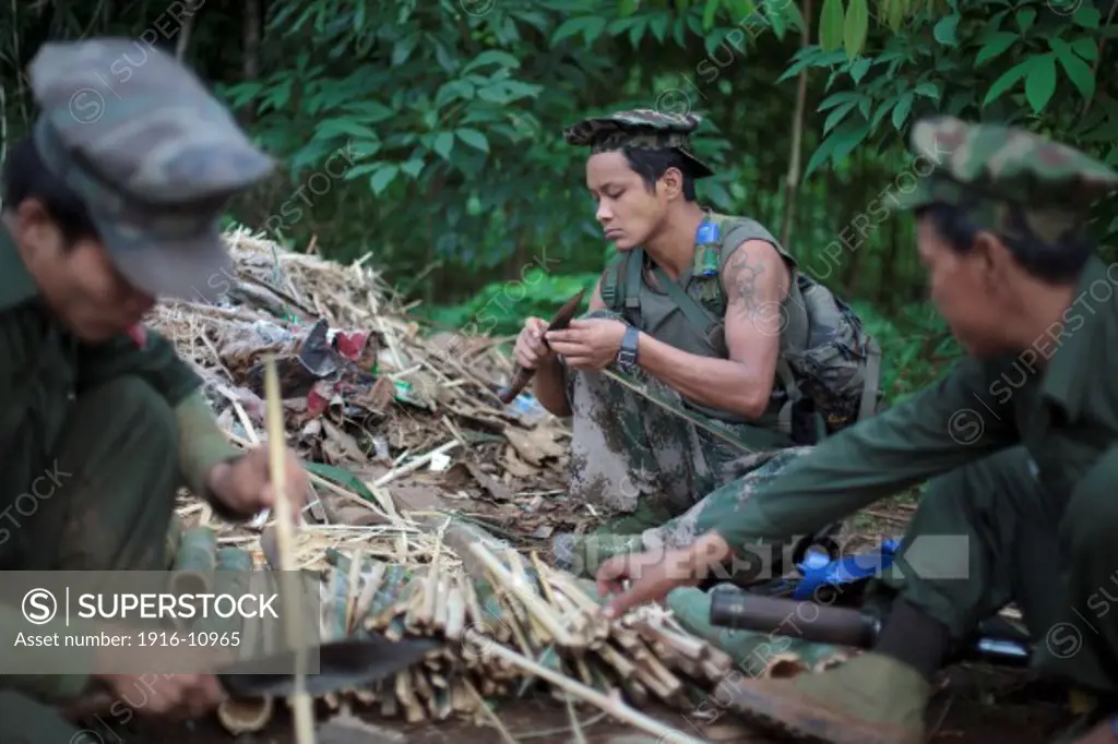 KIA's members sharpen bamboo's sticks for put on the ground of the jungle like traps, in Rubber Hill Post in the frontline, Laja Yang village outskirts of Laiza, Kachin State, Myanmar on August 8, 2012.