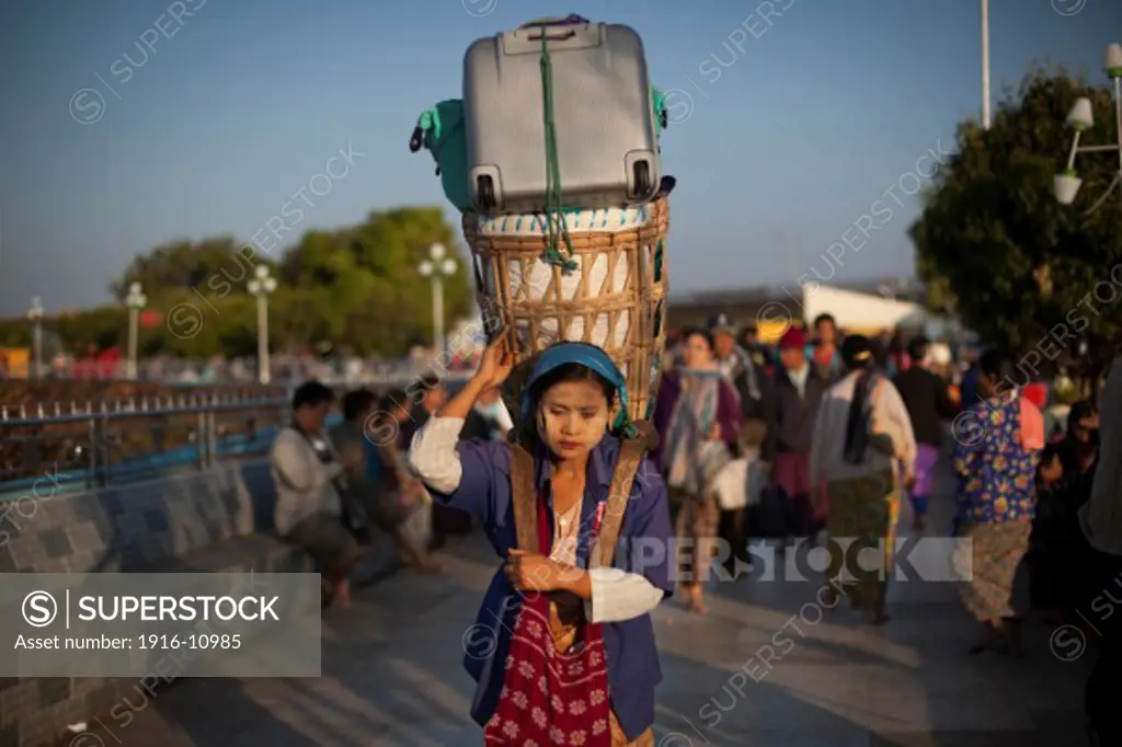 A woman carry the tourists luggage from the hotel to the bus station Kyaiktiyo Pagoda 'Golden Rock' at Kyaiktiyo, Myanmar on Saturday, 1, Feb. 2014.