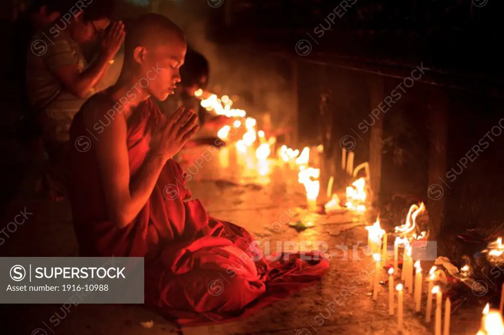 A monk pray in Kyaiktiyo Pagoda 'Golden Rock' in Kyaiktiyo Mon state, Myanmar, Saturday, May 11, 2013.