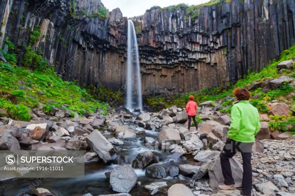 tourists in Svartifoss waterfall. Skaftafell National Park. Iceland.