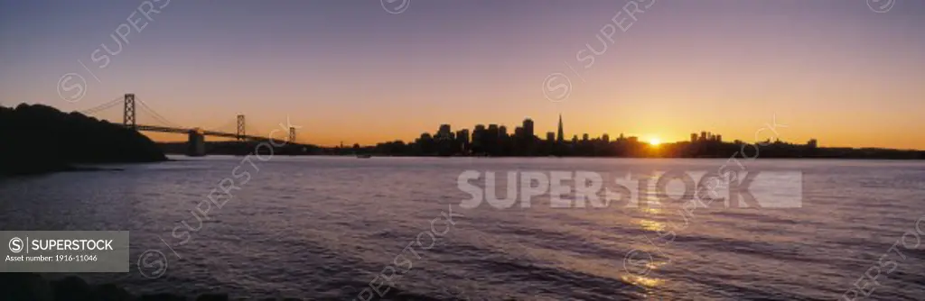San Francisco California skyline and Oakland Bay Bridge view across San Francisco Bay from Treasure Island at sunset