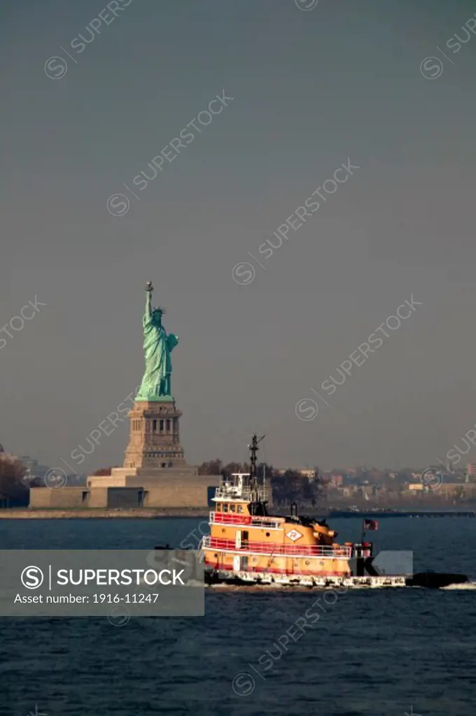 Tug boat on the Hudson River with Statue of Liberty in background, New York, NY