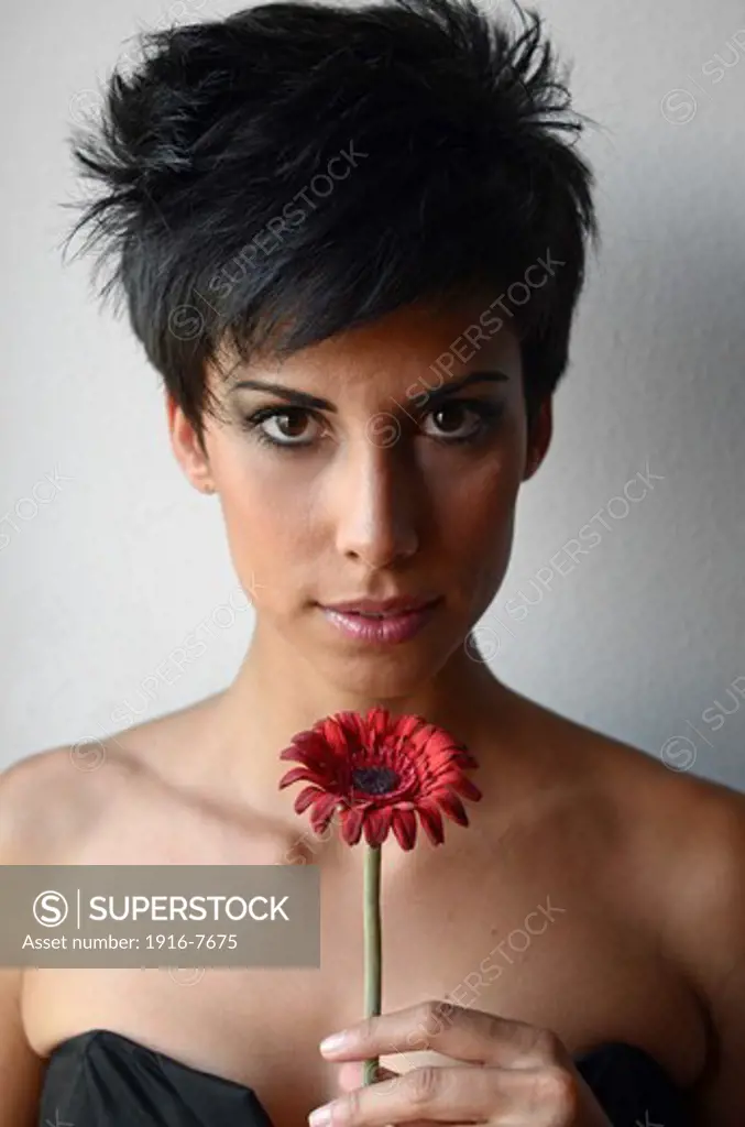 Attractive short haired woman holding  red flower