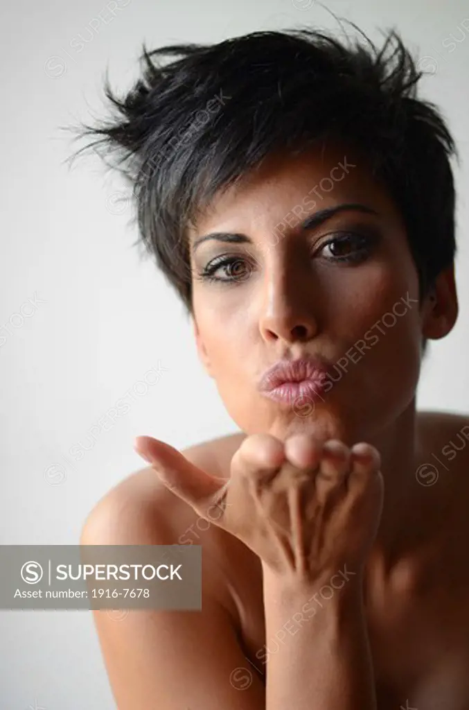 Attractive short haired woman blows kiss