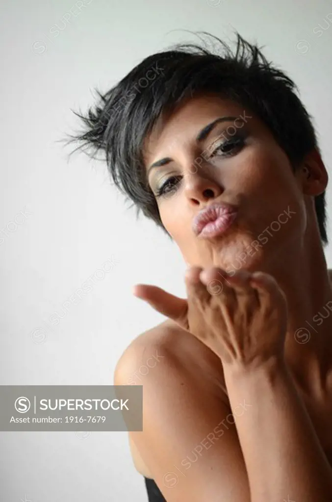 Attractive short haired woman blows  kiss