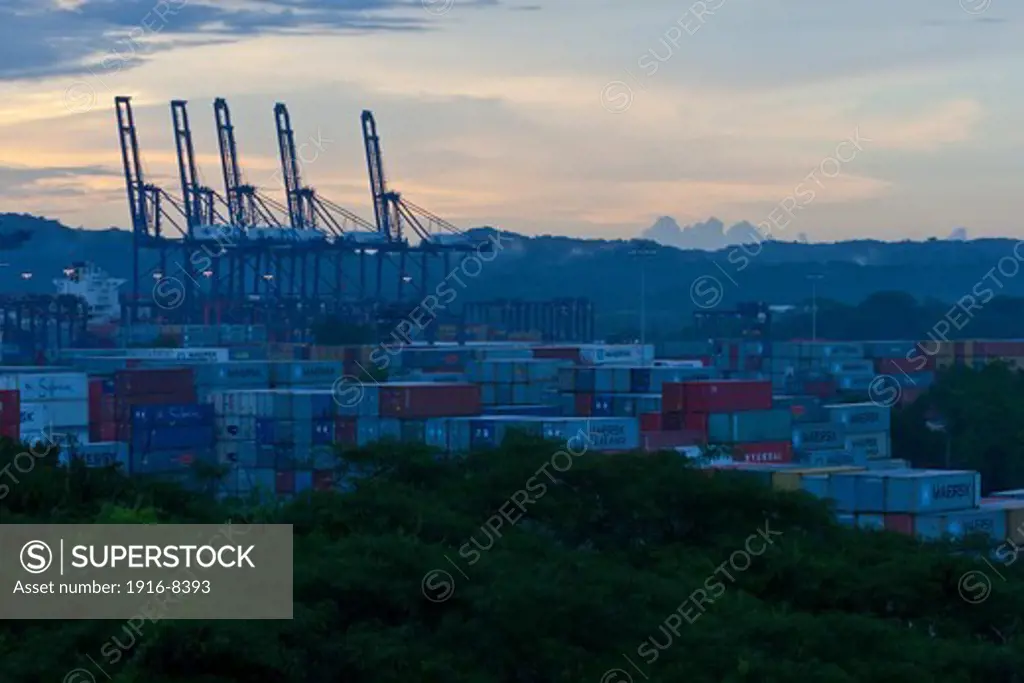 Cranes and shipping containers on sunset at Miraflores, Panama Canal.