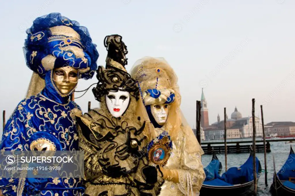 People dressed for the Carnival in Venice Italy.  Carnival or Carnevale in Italian, is a celebration for the 10 days before Lent, the Christian time of fasting before Easter Sunday.  People come from all over the globe to participate in the celebration that is centered in Piazza San Marco.  They dress in elaborate costumes with masks.  There are performaces of the Commedia dell'arte as well as parades throughout the city.