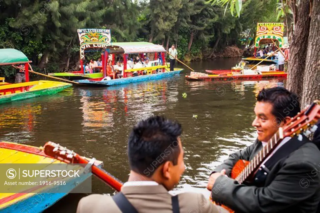 Musicians waiting to be hired and Trajineras on Canal, Xochimilco, Mexico City, Mexico