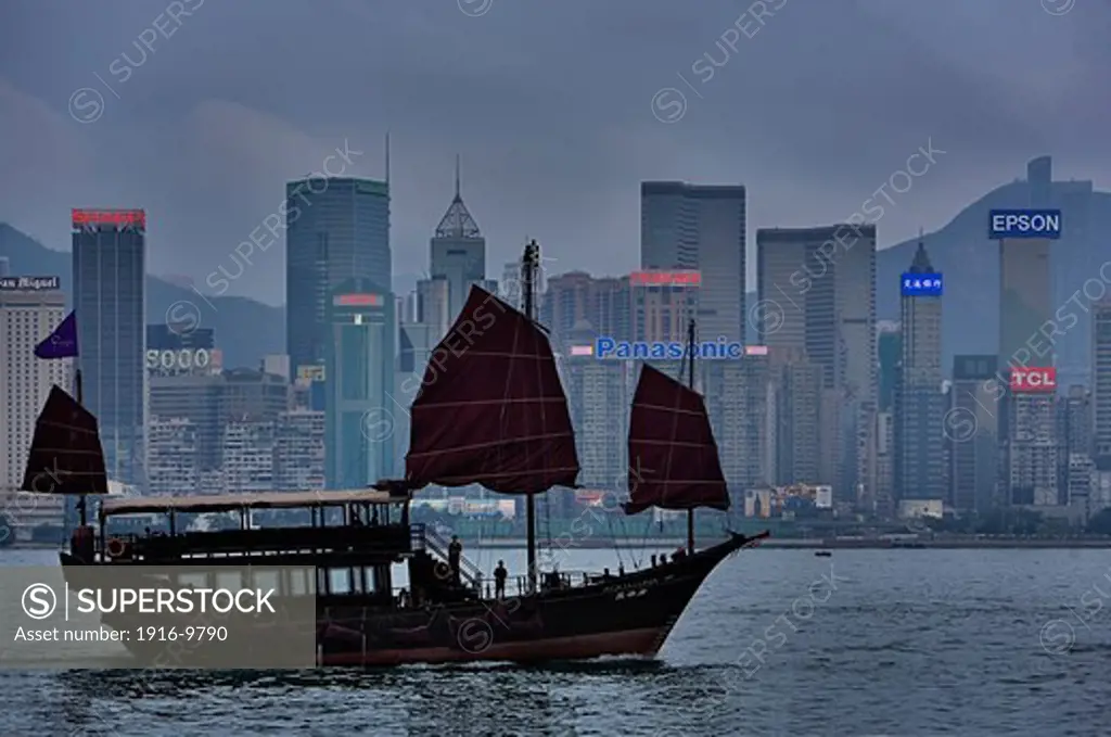 Traditional Sailing boat in Victoria Harbour with City Skyline in the Background,Hong Kong, China